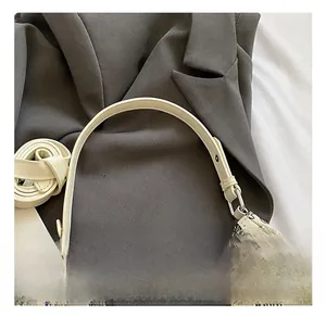 Detail view of graffiti print bag with cream PU leather, round handle and metal buckles