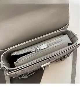 Detail shot of grey leather handbag interior with a smooth silver metal zipper pocket