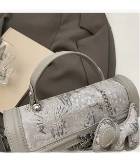 Detailed macro view of light grey jacquard fabric bag with silver buckle and chain strap