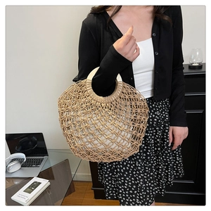 Detail of woven straw handbag with round wooden handles and white fabric lining