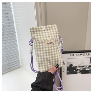 Detailed shot of green gingham canvas phone bag with white snap button and purple cord strap