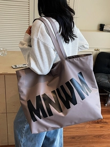 Grey-purple large capacity tote bag with MNWM print shown in a home setting