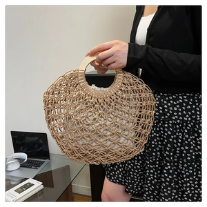 Detail of hollow woven summer handbag with round wooden handle and drawstring liner bag