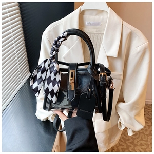 Détail du sac seau en PVC transparent avec fermoir doré et foulard à damier au manche
