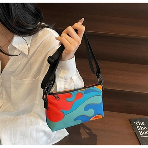 Close-up of adjustable strap and vibrant fluid print on a compact crossbody bag