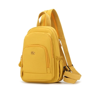 Side view of yellow waterproof nylon backpack featuring multiple pockets and metal logo