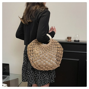 Detail of hollow woven straw tote bag with round handles and inner fabric lining