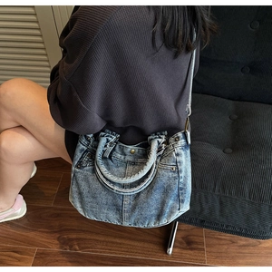 Dettaglio della borsa tote in denim blu vintage con tasche stile jeans e rivetti