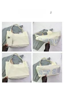 Detail view of large white canvas tote bag with blue lettering showing size and dimensions