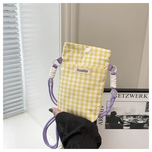 Detailed shot of yellow plaid canvas mini bag with purple rope strap and button closure