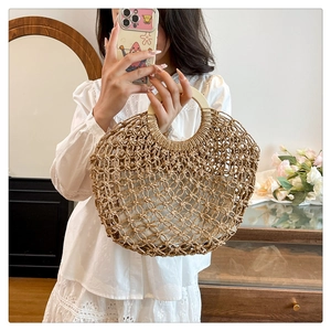 Detail of hollow woven summer handbag with round wooden handles and fabric lining