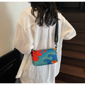 Abstract colorful wavy print crossbody bag with adjustable wide black strap on model