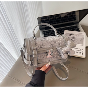 Detail of grey jacquard handbag with vintage embroidery and heart wing lock clasp