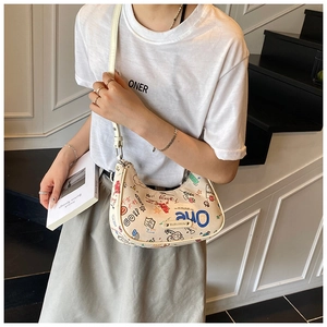 Detail of trendy graffiti print shoulder bag styled with a minimalist outfit on a staircase