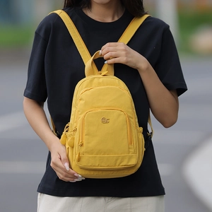 Close-up of vibrant yellow mini backpack with adjustable straps and front zipper pocket