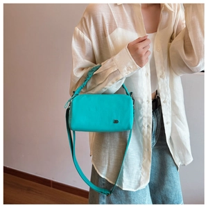Detail of tiffany blue crossbody bag featuring pleated handle and silver DD metal logo