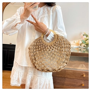 Close-up of handmade woven straw bag featuring circular wood handles and inner lining