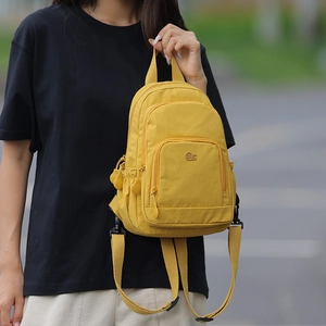Detailed view of yellow nylon mini backpack with functional zippers and mS metallic logo