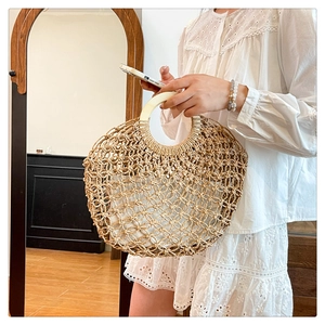 Detail of hollow woven straw bag with round wooden handles and white cotton lining