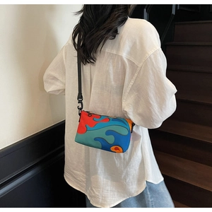 Macro view of a colorful wave pattern crossbody bag on a model in a minimalist setting