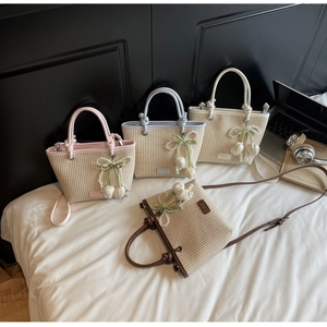Detail view of straw woven texture handbags with pearl flower charms in four colors