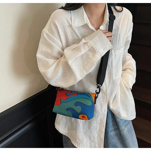 Detailed side view of multi-color patchwork crossbody bag showing wave patterns and strap