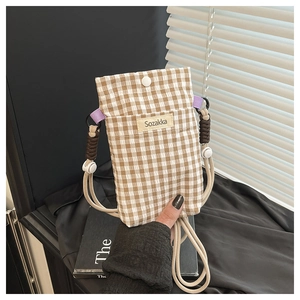Detail of checkered canvas crossbody phone bag featuring a snap button and rope strap