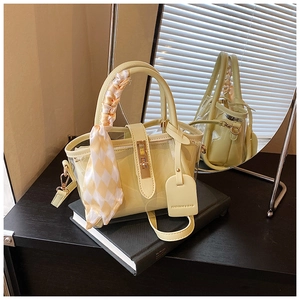 Détail du sac seau jaune avec couche en PVC, poignée en foulard de soie et fermoir en métal