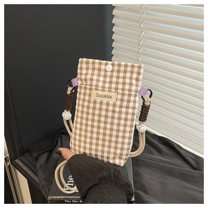 Detail of checkered canvas phone bag with resin button closure and woven brand label