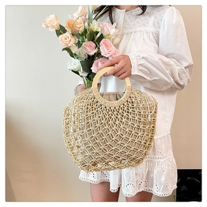 Detail of woven mesh handbag with round wooden handles and cotton inner pouch