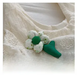 Close-up of floral fabric accessory showing detailed green stitching and cotton texture