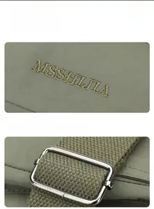 Detail view of army green nylon square bag showing embroidery logo and silver strap buckle