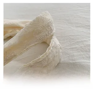 Detail showing the white lace floral texture and sturdy cotton handle of the tote bag