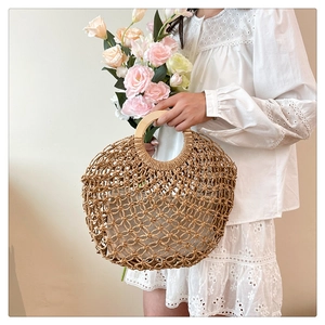 Detailed texture of hollow woven straw handbag with elegant round wooden handle and fabric liner