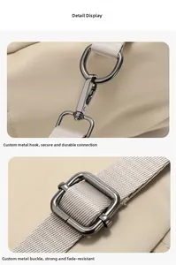 Detail of durable dark silver metal swivel hooks and adjustable buckles on beige nylon bag