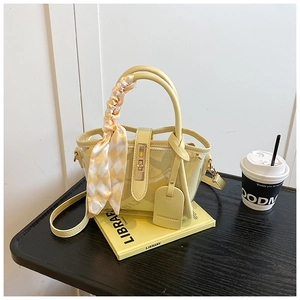 Détail du sac seau en PVC jaune avec pochette, foulard à carreaux et étiquette