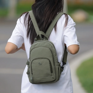 Olive green nylon backpack detail showing spacious compartments and adjustable straps