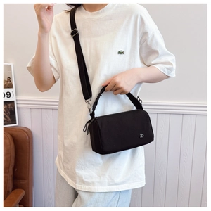 Detail of black crossbody bag with ruched handle and silver logo on the front