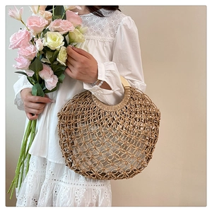 Detail of woven straw tote bag with round wooden handles and fabric lining for summer