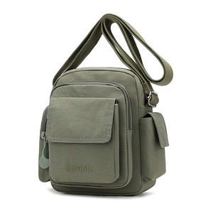 Detail view of olive green nylon crossbody bag with multiple pockets and brand logo