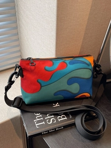Chic color-block crossbody bag with abstract vibrant prints and wide nylon shoulder strap
