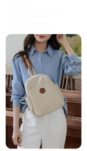 Detail of beige Oxford fabric backpack with leather logo patch for office and travel
