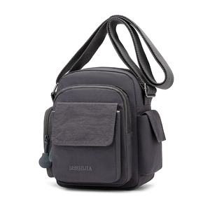 Detail view of the charcoal gray crossbody bag showing front pocket and durable nylon texture