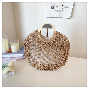Close-up of a woven hollow beach bag featuring round wooden handles and fabric liner