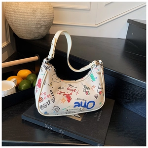 Detail view of white crescent baguette bag featuring colorful street graffiti and metal logo