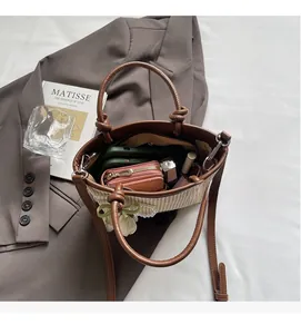 Detail view of woven straw bucket bag interior with phone and wallet inside