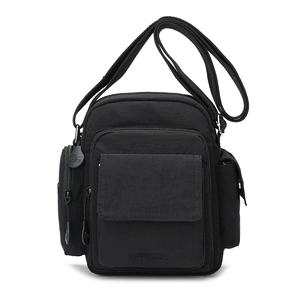 Detail view of black nylon crossbody bag featuring multi-pocket design and adjustable strap