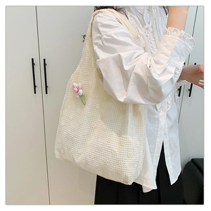 Detail of floral lace tote bag featuring 3D flower charm and intricate crochet texture