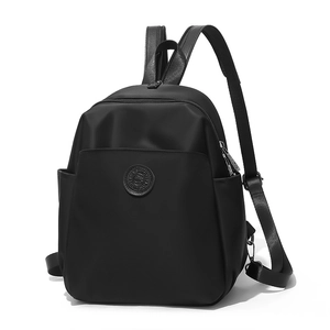 Detail view of water-resistant black backpack with front zipper pocket and side mesh slots
