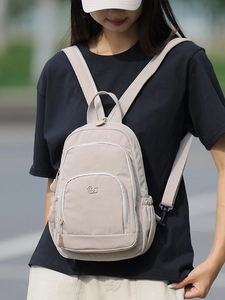 Versatile beige nylon backpack for women featuring multiple pockets and adjustable straps